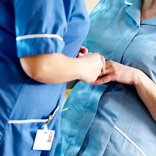 close up of the hands of two nurses talking